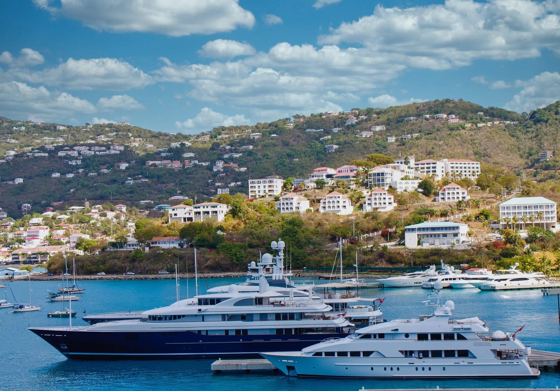Megayachts berthed below the green hills of Sint Maarten