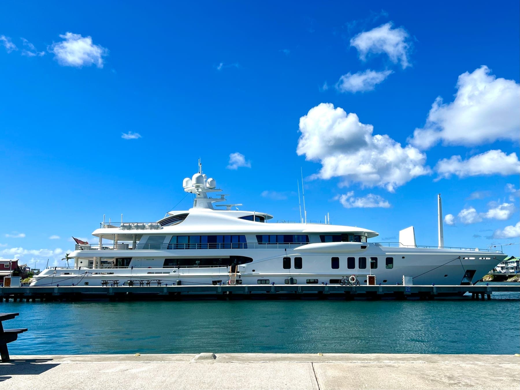 A white megayacht alongside the quay under a bright Sint Maarten sky